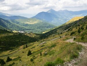 krajobraz-wzgorz-pokrytych-zielenia-z-gorami-skalistymi-min